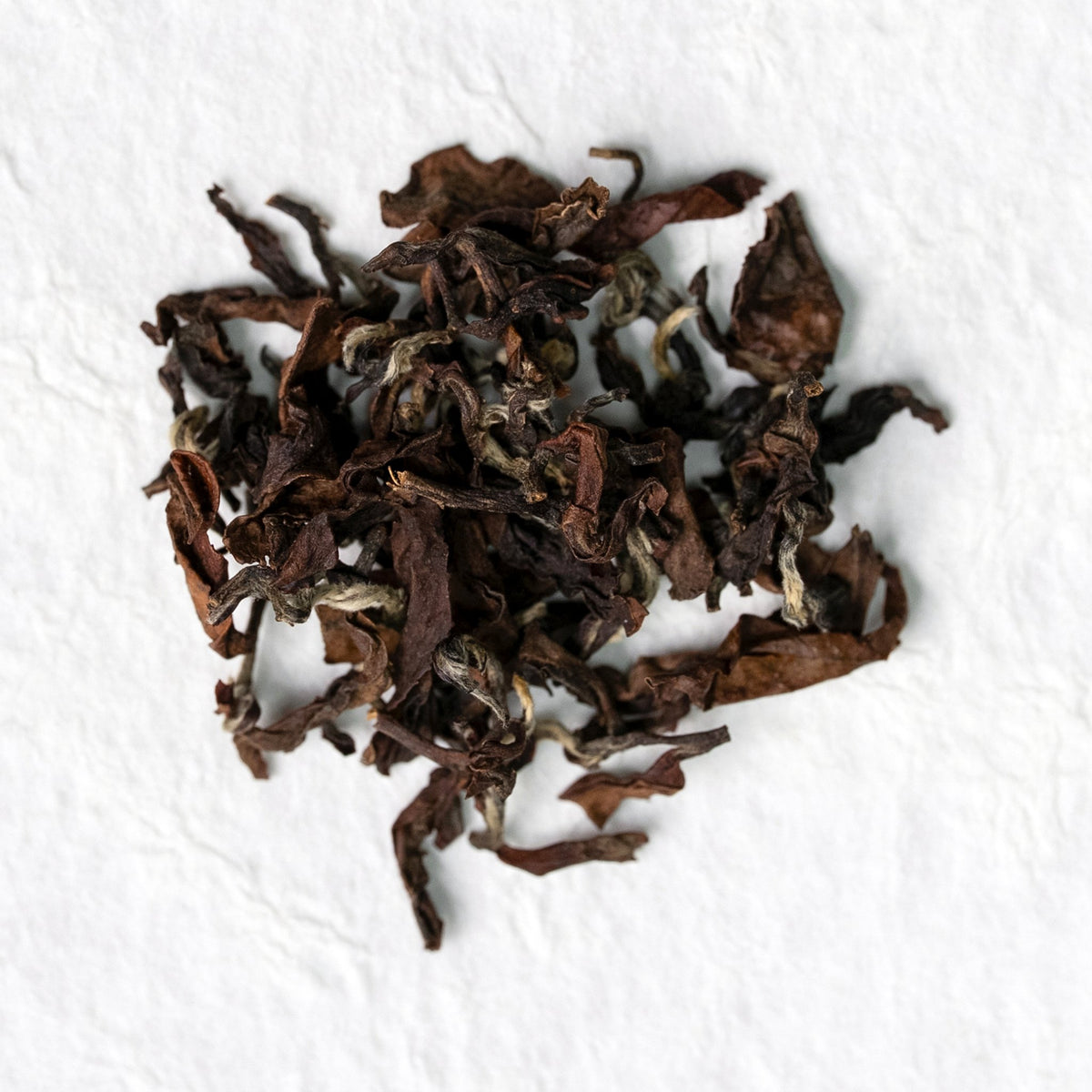 Oriental Beauty Oolong Tea loose leaves on a light textured surface