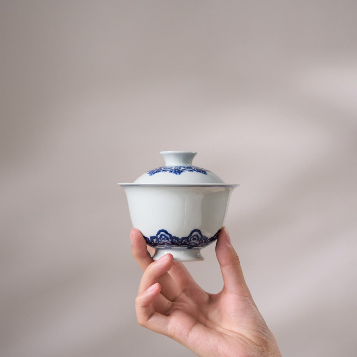 Baoxiang Floral Blue-and-White Porcelain Gaiwan held in hand for scale