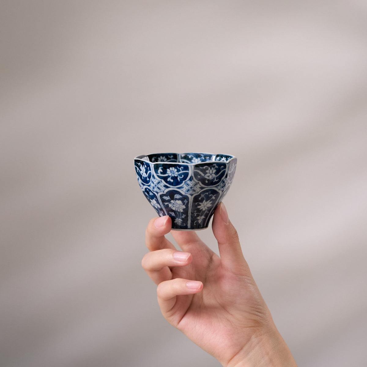 Floral Blue-and-White Octagonal Tea Cup held in hand for scale
