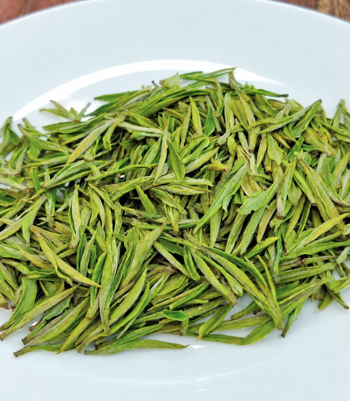 Long green tea leaves on a white plate