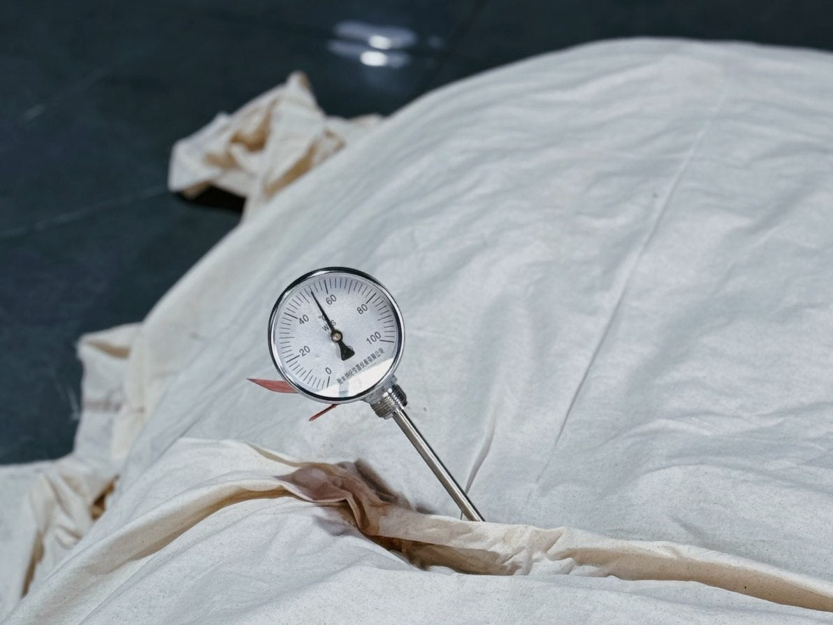 Cloth-covered tea with a temperature gauge