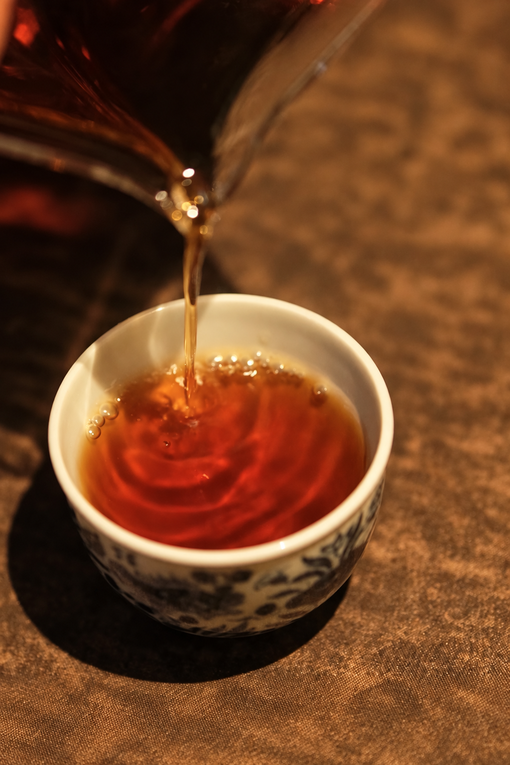 Amber tea poured into a small white-and-blue cup