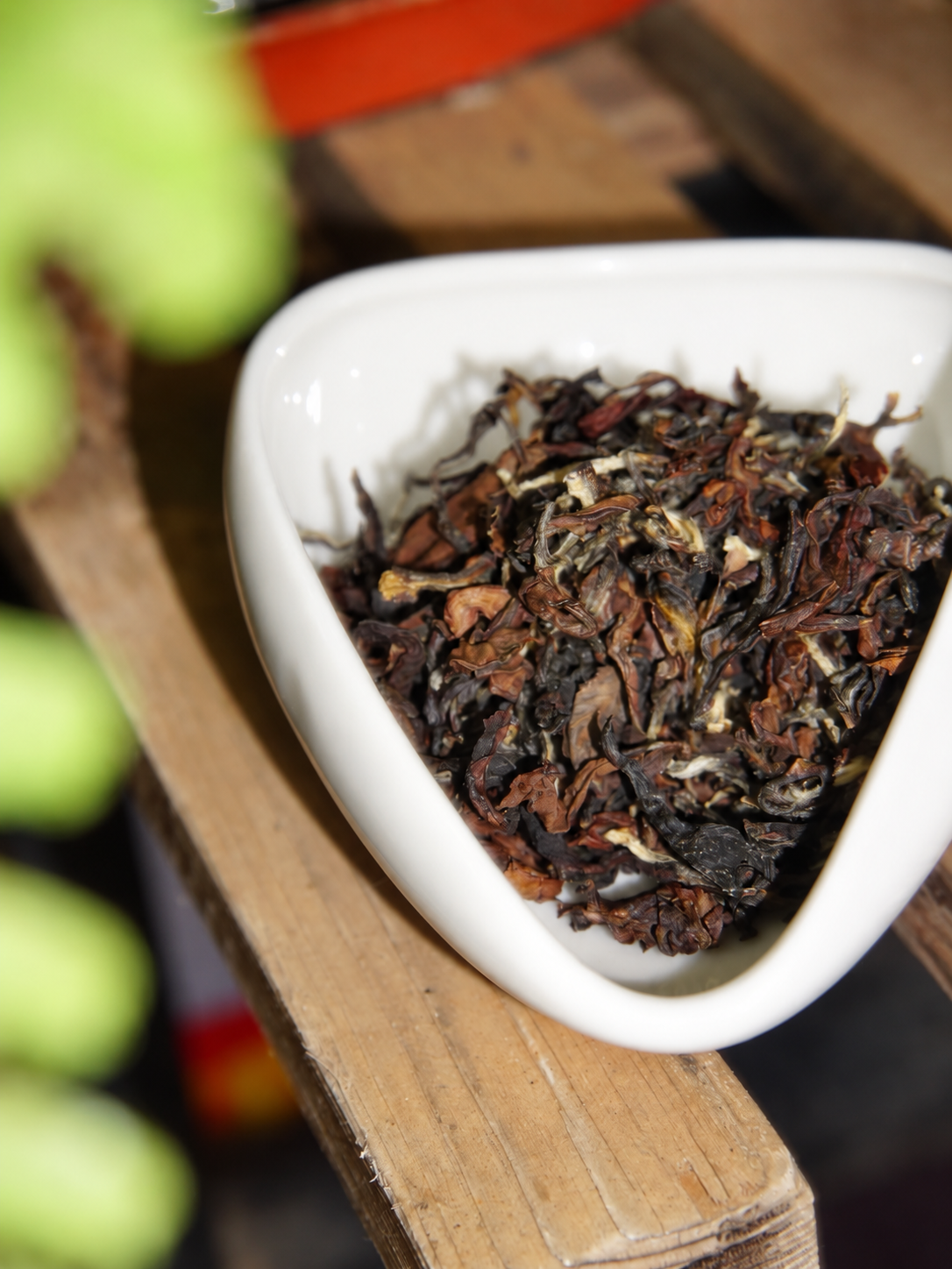 Curled brown leaves and pale buds in a white dish