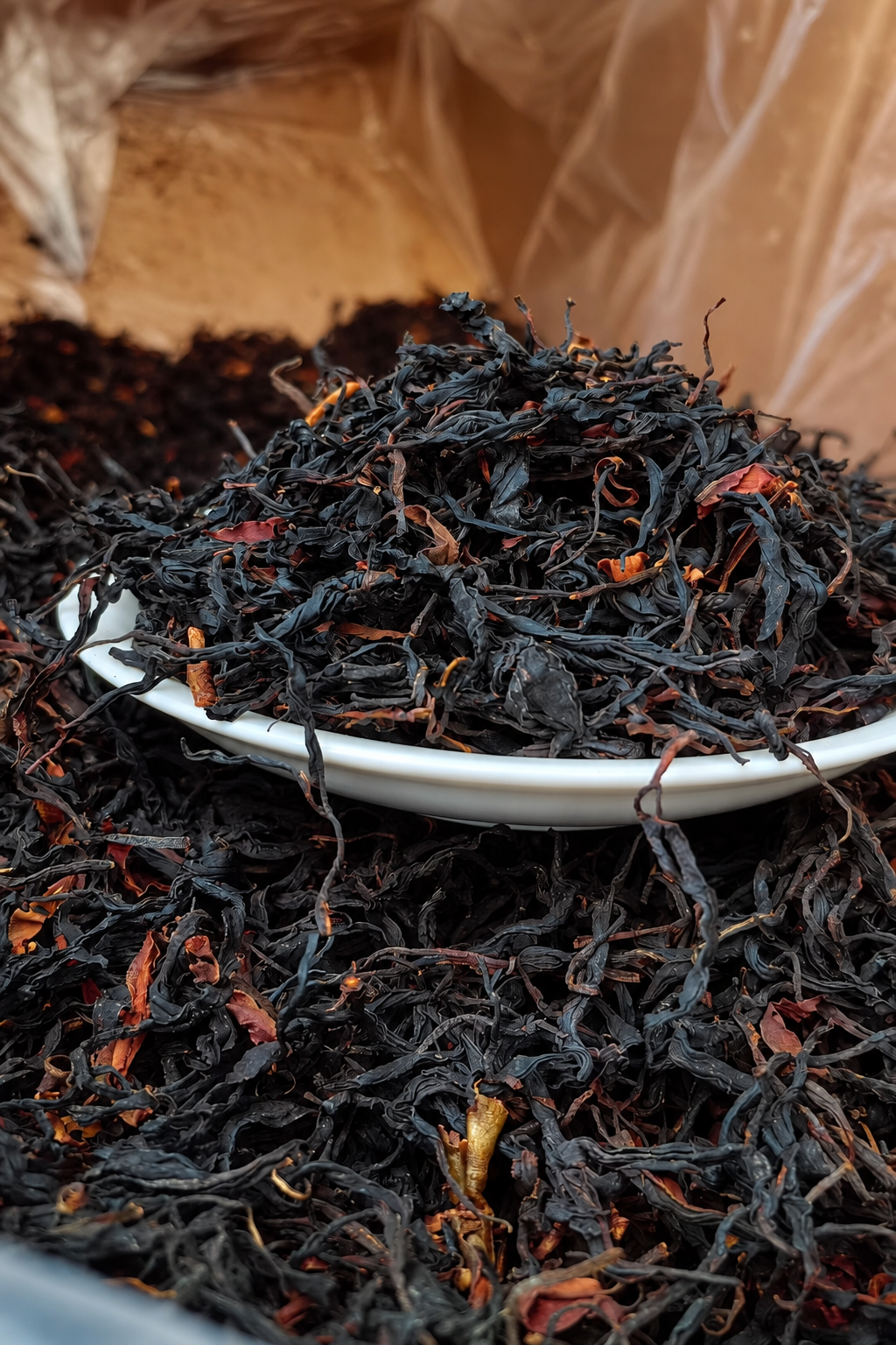 Dark twisted dry leaves piled on a white plate