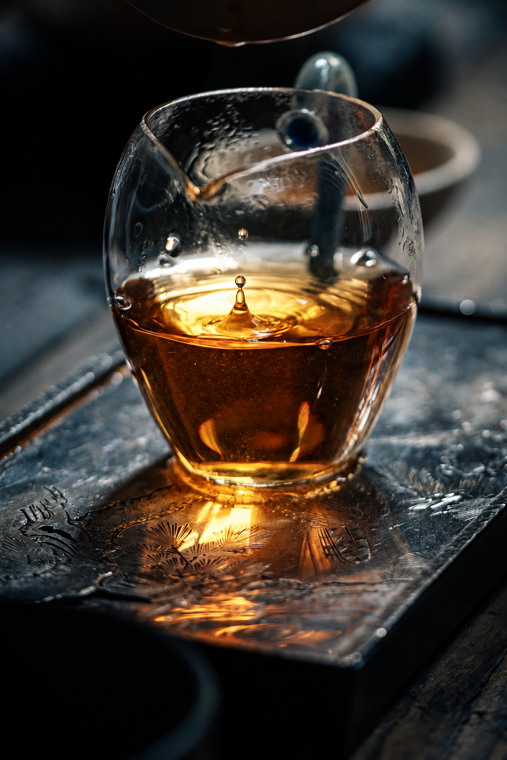 Amber tea being poured into a glass on a tea tray