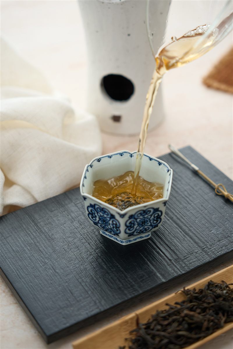 Tea being poured into a blue-and-white porcelain cup